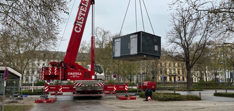 Ein Container hängt an einem Kran in der Luft. Ein Container hängt an einem Kran in der Luft.