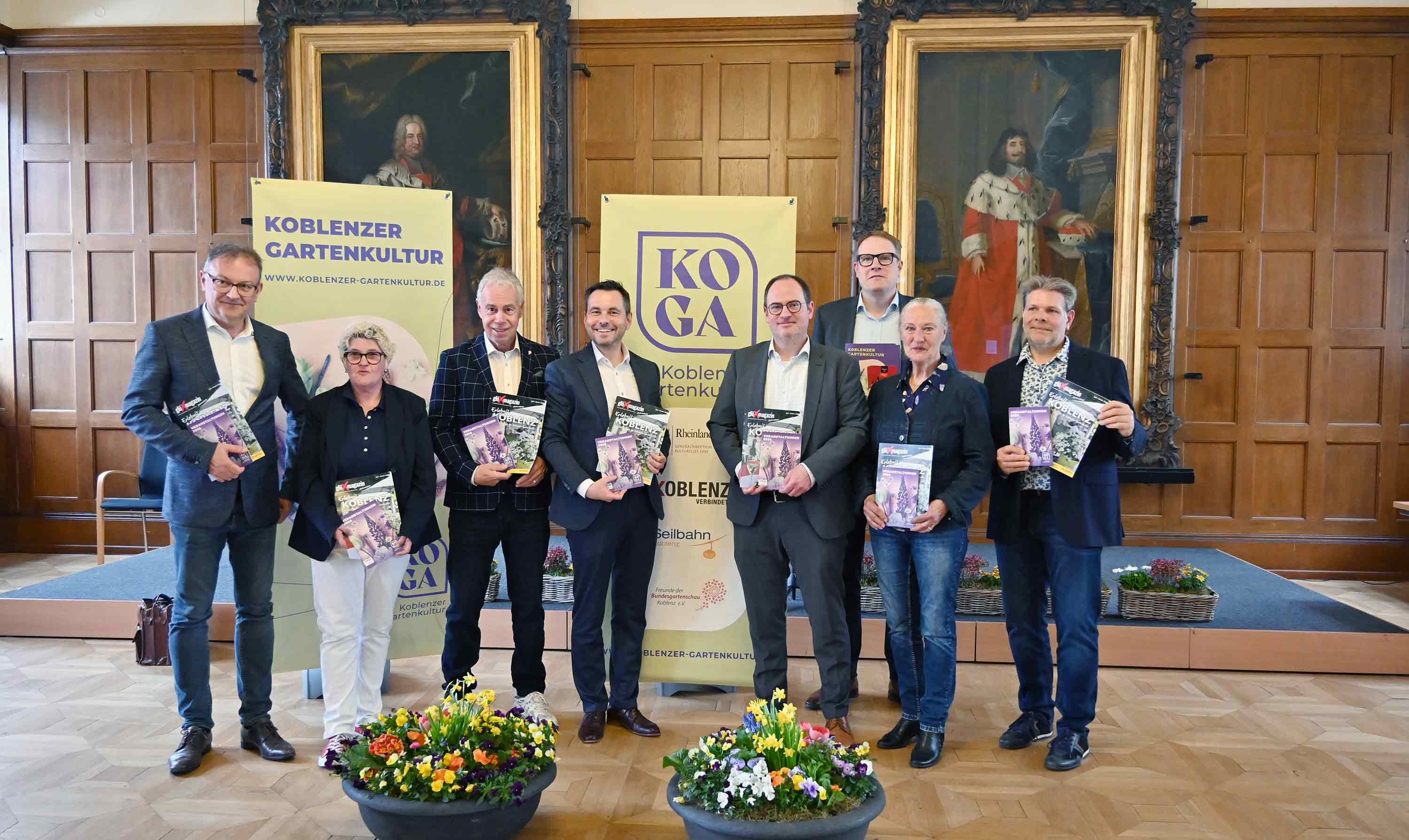 Dank einer starken Kooperation startet die Koblenzer Gartenkultur mit zahlreichen attraktiven Veranstaltungen in ihre 15. Saison. Oberbürgermeister David Langner (Mitte) und Kultur- und Bildungsdezernent Ingo Schneider (4. v.r.) stellten die neue Programmbroschüre sowie das Glüxmagazin „Erlebnis Koblenz“ von Lotto Rheinland-Pfalz vor.