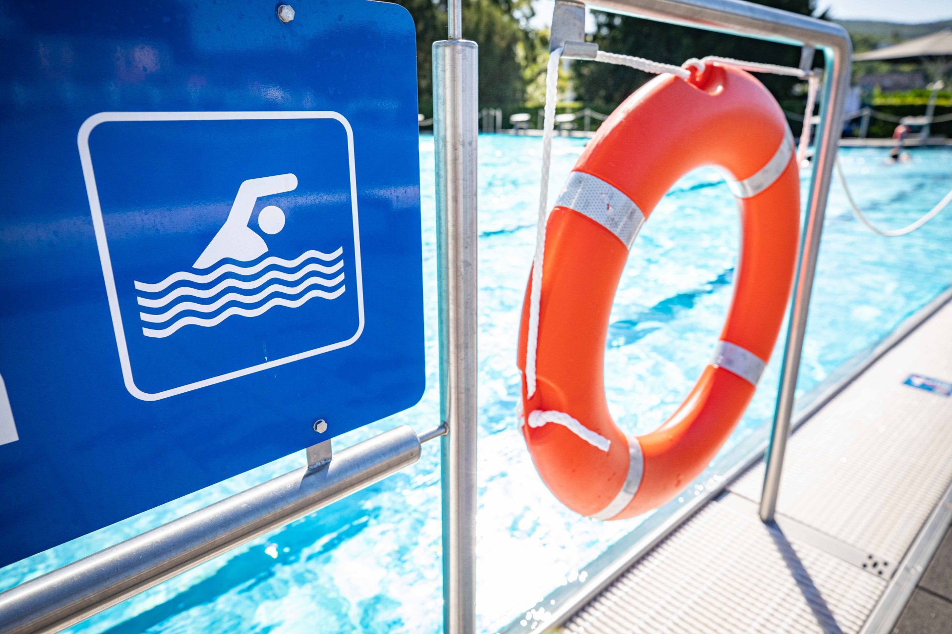 Ein Schild mit einem Schwimmersymbol neben einem Rettungsring.