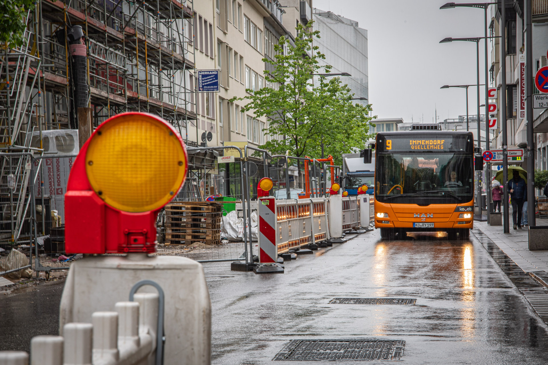 Ein Bus fährt an einer abgesperrten Baustelle vorbei.