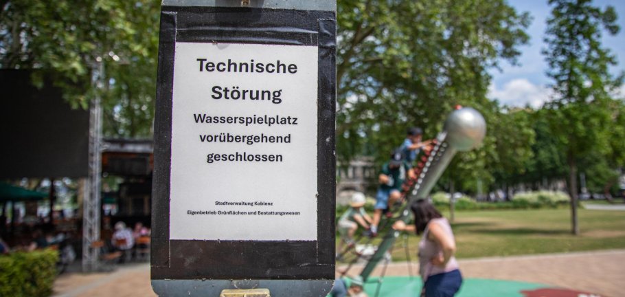 Ein Schild steht an einem Spielplatz und weist auf einen technischen Defekt hin. Ein Schild steht an einem Spielplatz und weist auf einen technischen Defekt hin.