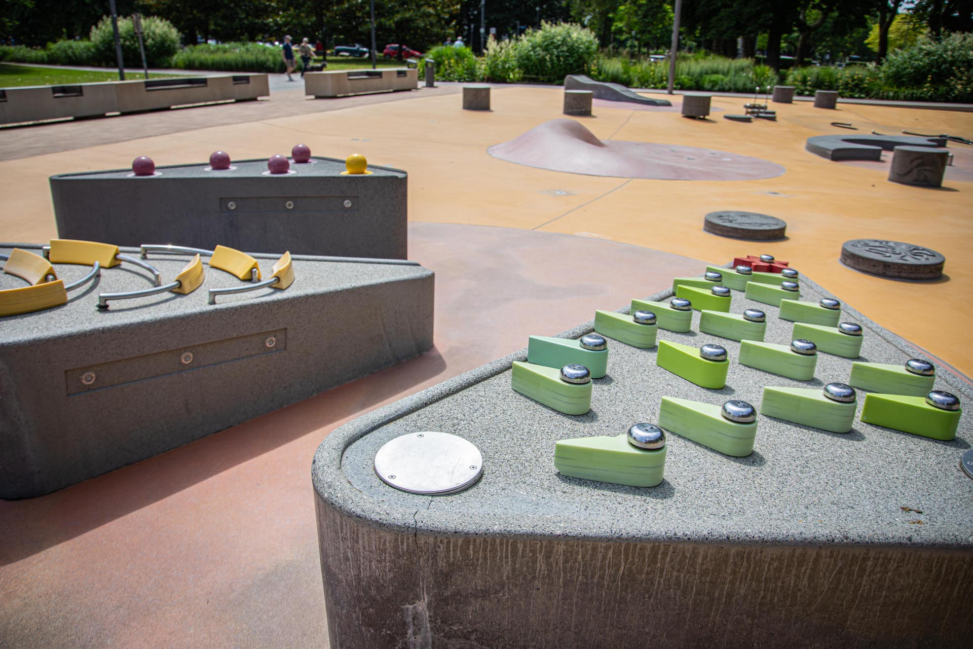 Spielgeräte stehen auf einem Wasserspielplatz, ohne, dass Wasser fließt.