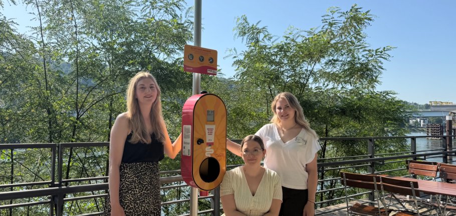 Der Sonnencreme-Spender stammt aus einer gemeinsamen Initiative der Klimaleitstelle der Stadt Koblenz (Emilie Hammer, mitte), des Kultur- und Schulverwaltungsamts (Rebekka Jachmig, links) und der Koblenz Touristik GmbH (Joelina Wolter, rechts).  