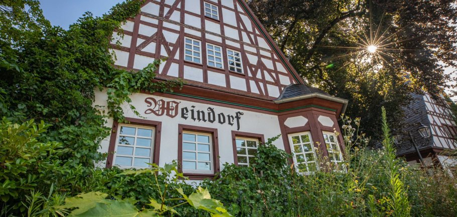 Ein Fachwerkgebäude im Grünen bei Sonnenschein.