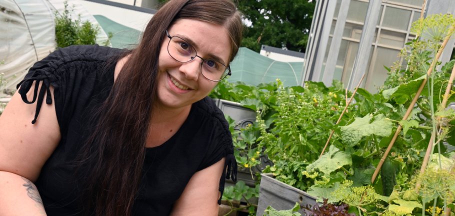 Eine Frau hält ein grünes Blatt in ihren Händen.