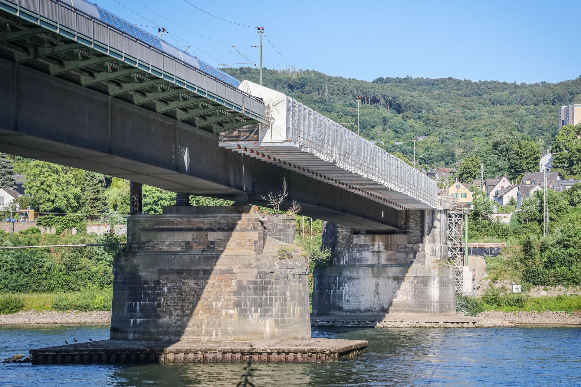 Eine Brücke führt über einen Fluss. Auf der Brücke ist eine Baustelle zu erkennen.