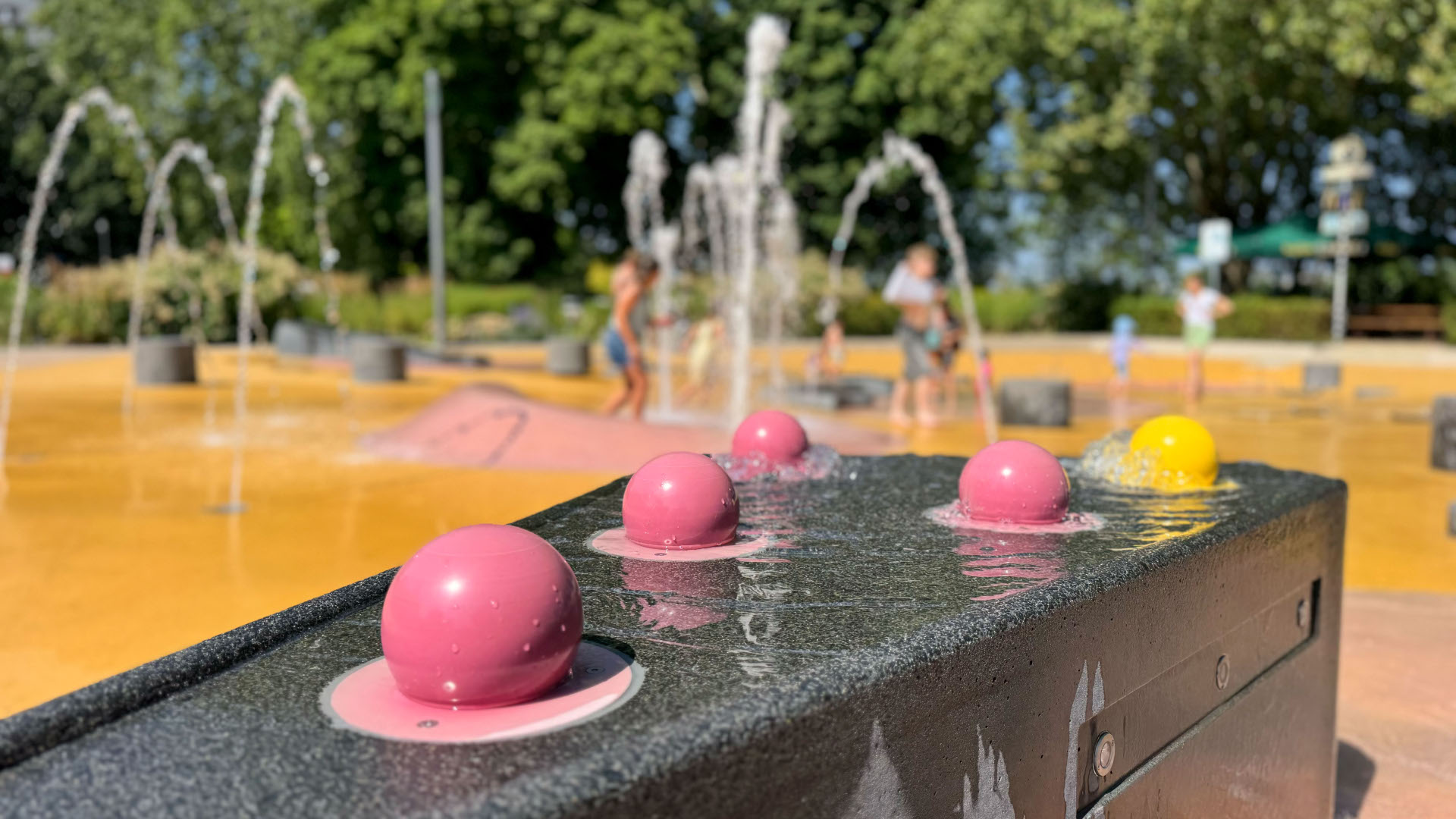 Wasser fließt über Spielgeräte auf einem Wasserspielplatz.