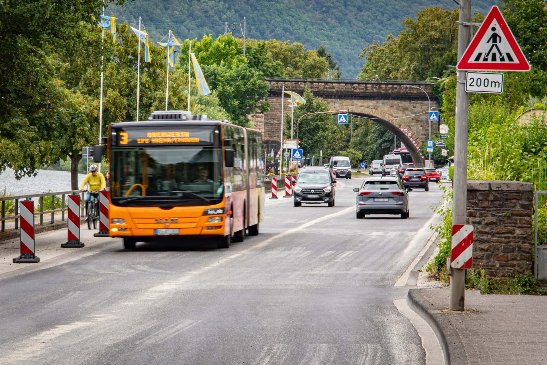 Ein Bus und Autos fahren auf einer Straße.
