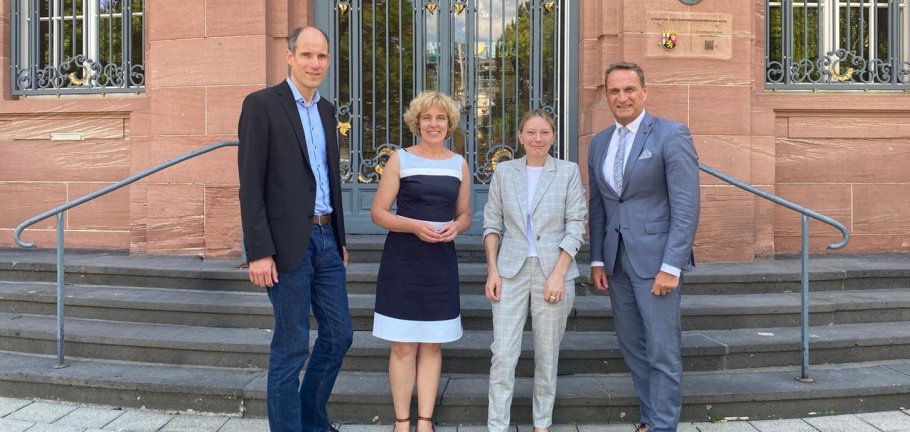 Zwei Frauen und zwei Männer stehen vor einer Treppe. Zwei Frauen und zwei Männer stehen vor einer Treppe.