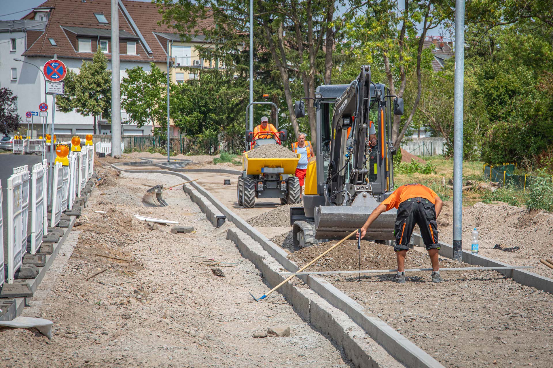 Bauarbeiter arbeiten an einer Straßenbaustelle auf dem Bürgersteig.