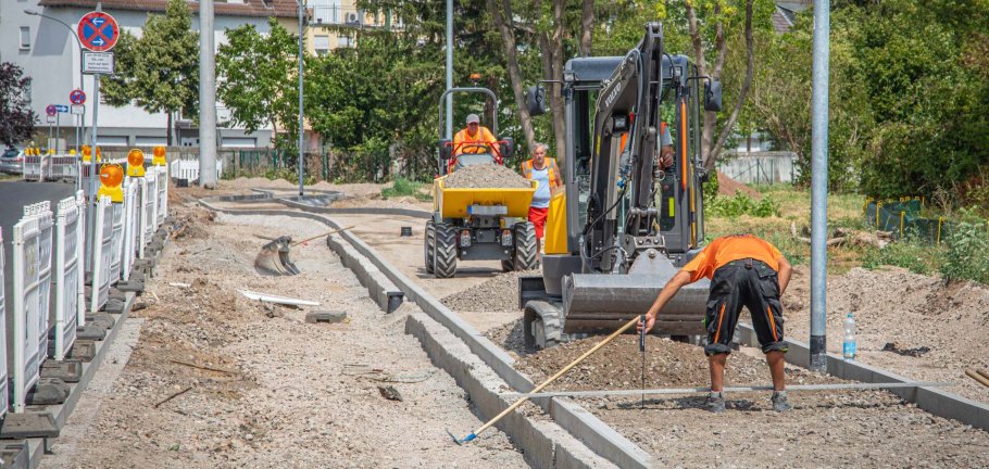 Bauarbeiter arbeiten an einer Straßenbaustelle auf dem Bürgersteig. Bauarbeiter arbeiten an einer Straßenbaustelle auf dem Bürgersteig.