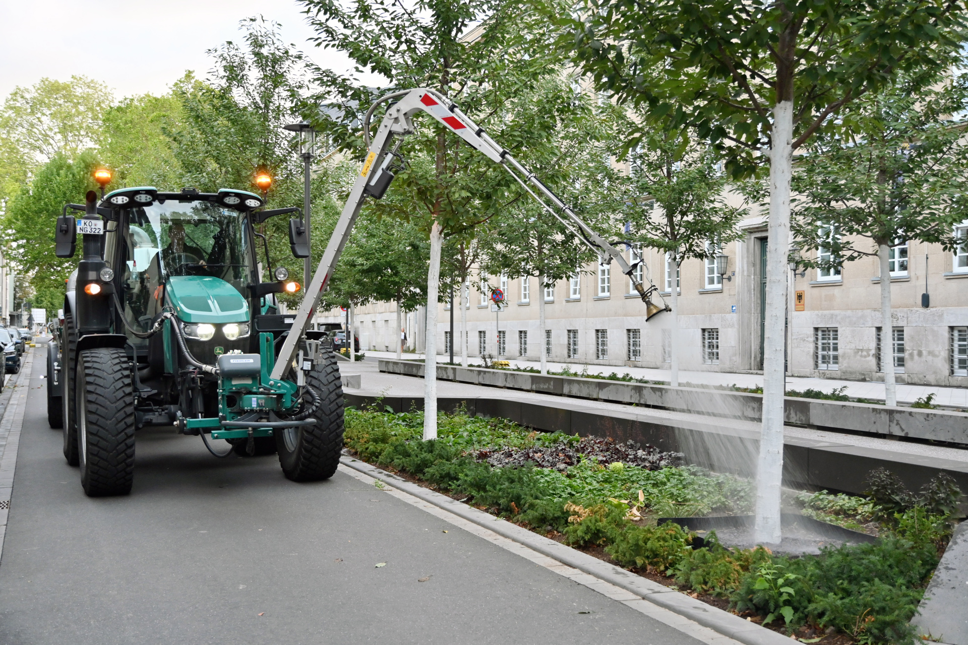 Ein Traktor bewässert einen Baum.