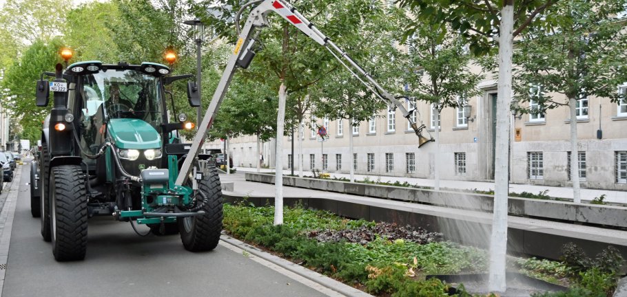Ein Traktor bewässert einen Baum. Ein Traktor bewässert einen Baum.