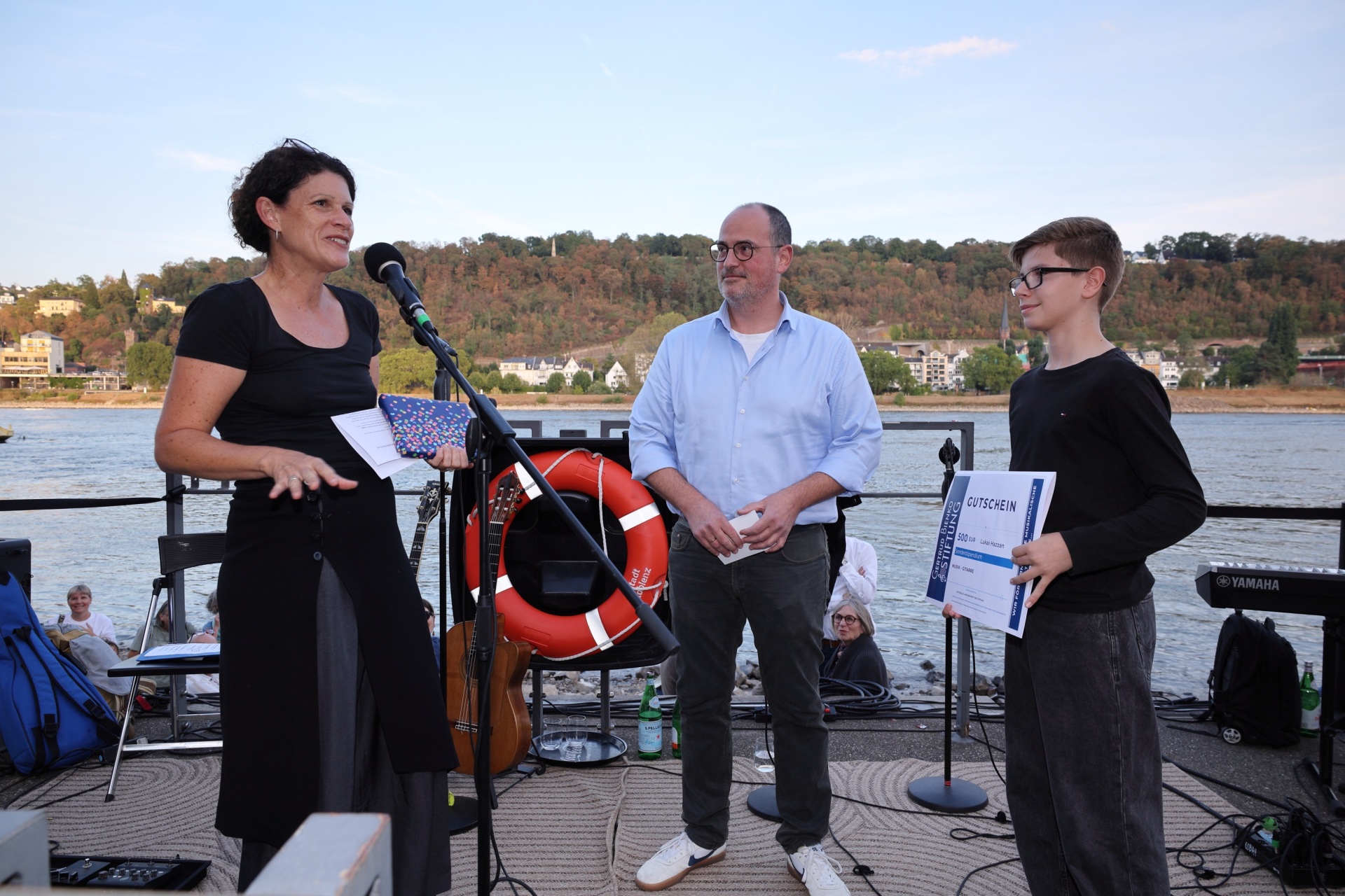 Eine Frau, ein Mann und ein Junge stehen an einem Fluss.