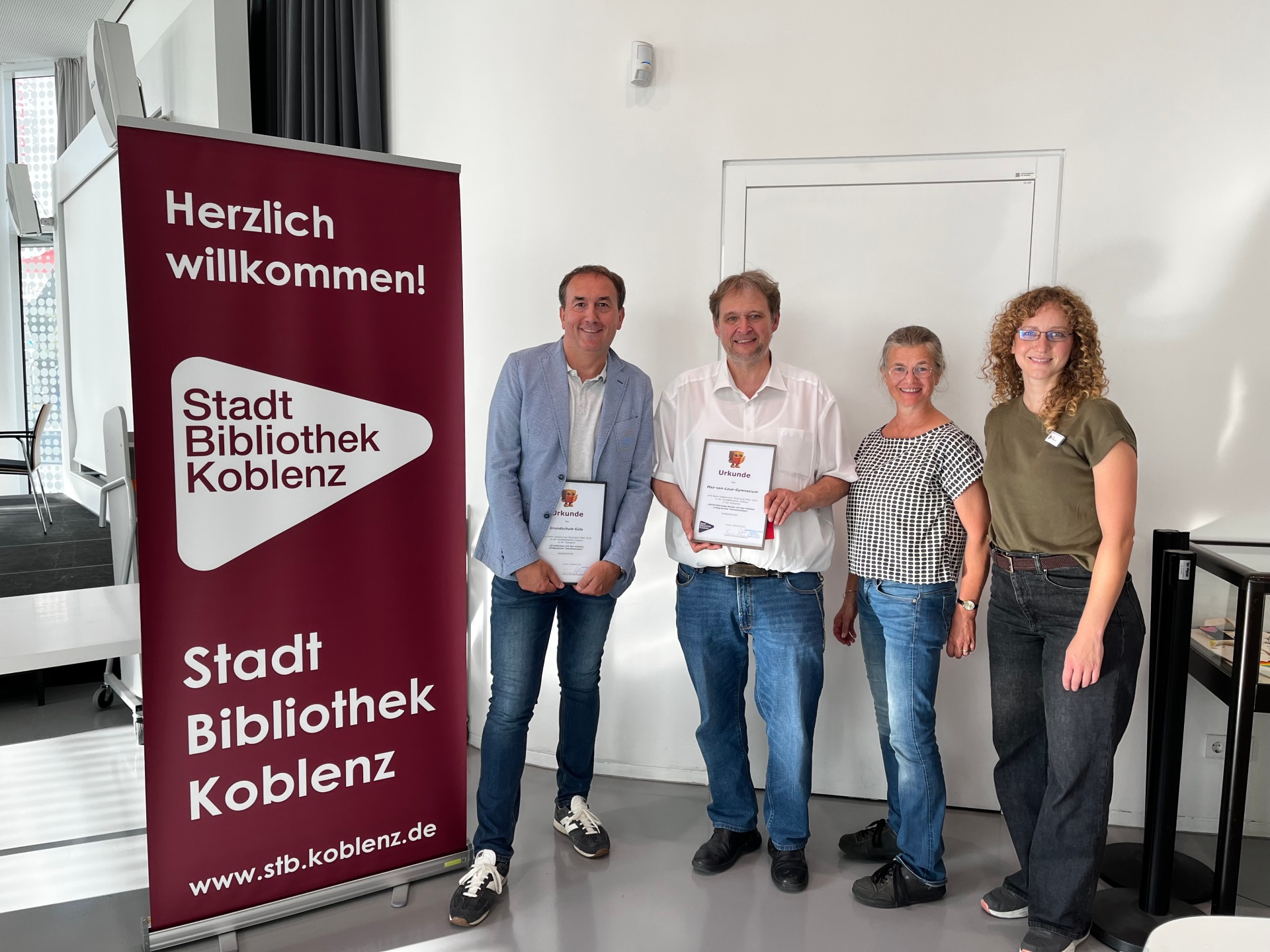 Schulauszeichnung im Rahmen des Lesesommers - v.l.: Peter Degen (Grundschule Güls), Frank Zimmerschied (Max-von-Laue-Gymnasium), Marie-Theres Schwaab (Förderverein), Marion Eickschen (Stadtbibliothek)