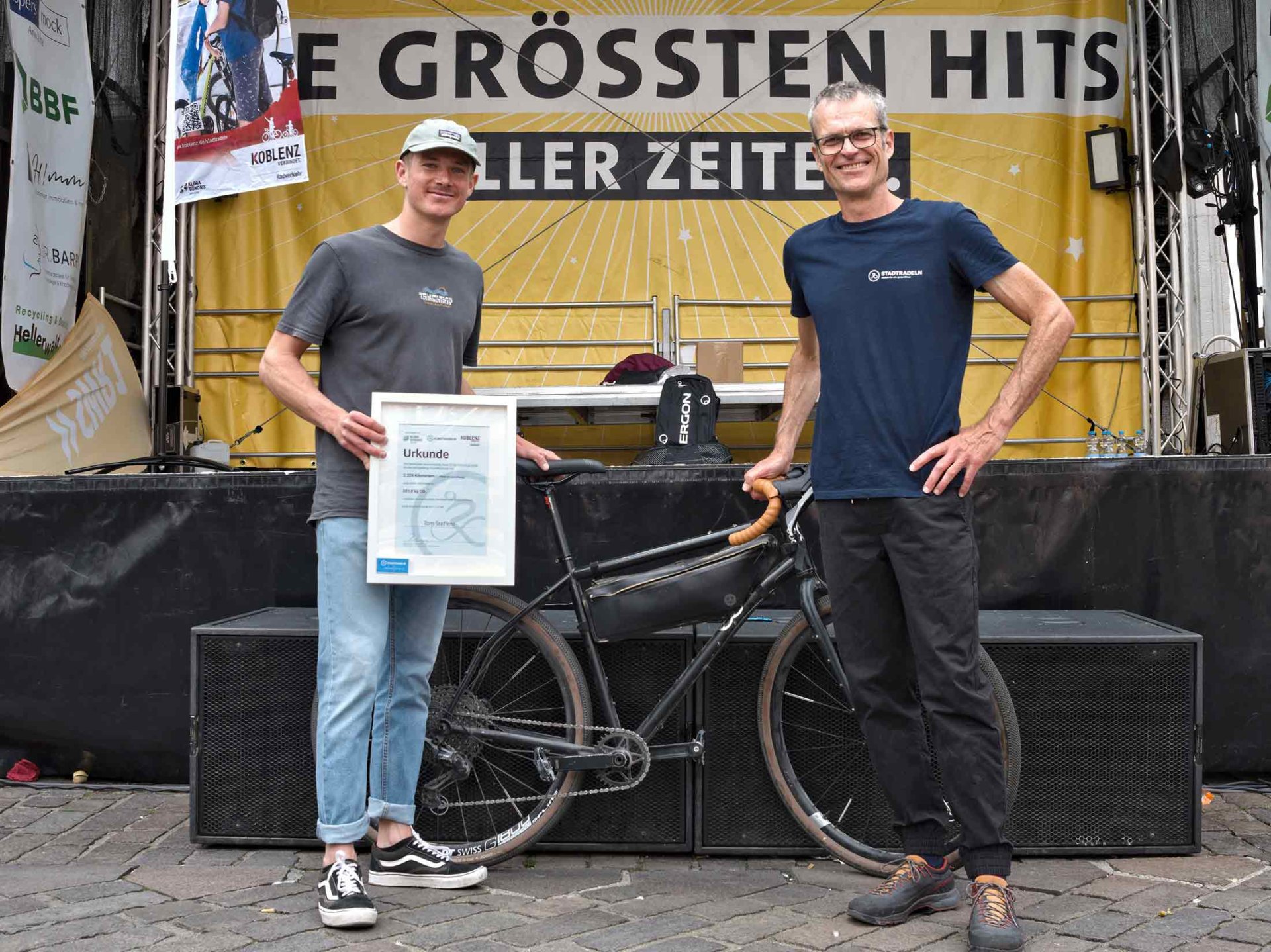 Glücksbringer Tom Steffens (links im Bild) zog die Lose bei der Abschlussveranstaltung. Er schaffte mit 2.328 km beim STADTRADELN die meisten Kilometer und wurde für diese Leistung von Ralph Emmerich im Auftrag von Oberbürgermeister David Langner bei der Abschlussveranstaltung der Kampagne mit einer Urkunde ausgezeichnet.