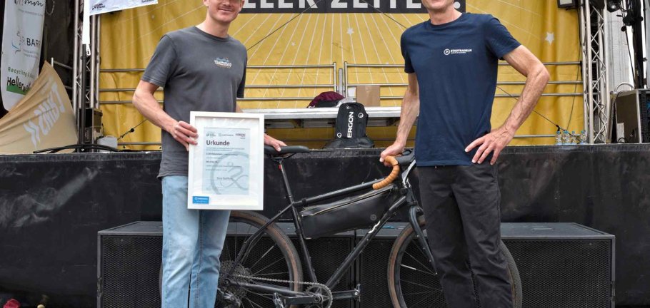 Glücksbringer Tom Steffens (links im Bild) zog die Lose bei der Abschlussveranstaltung. Er schaffte mit 2.328 km beim STADTRADELN die meisten Kilometer und wurde für diese Leistung von Ralph Emmerich im Auftrag von Oberbürgermeister David Langner bei der Abschlussveranstaltung der Kampagne mit einer Urkunde ausgezeichnet.