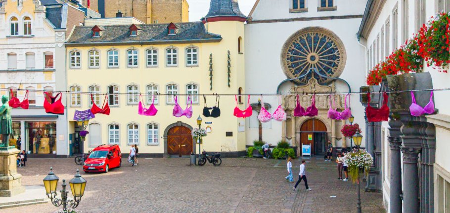 Pinke BHs hängen an einer Leine über einer Straße. Pinke BHs hängen an einer Leine über einer Straße.