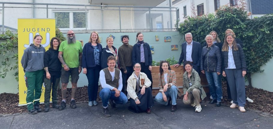 Mehrere Menschen stehen vor einer Wand für ein Gruppenfoto. Mehrere Menschen stehen vor einer Wand für ein Gruppenfoto.