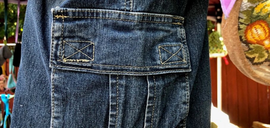 Ein Rucksack aus Jeans-Stoff hängt an einem Stand. Ein Rucksack aus Jeans-Stoff hängt an einem Stand.