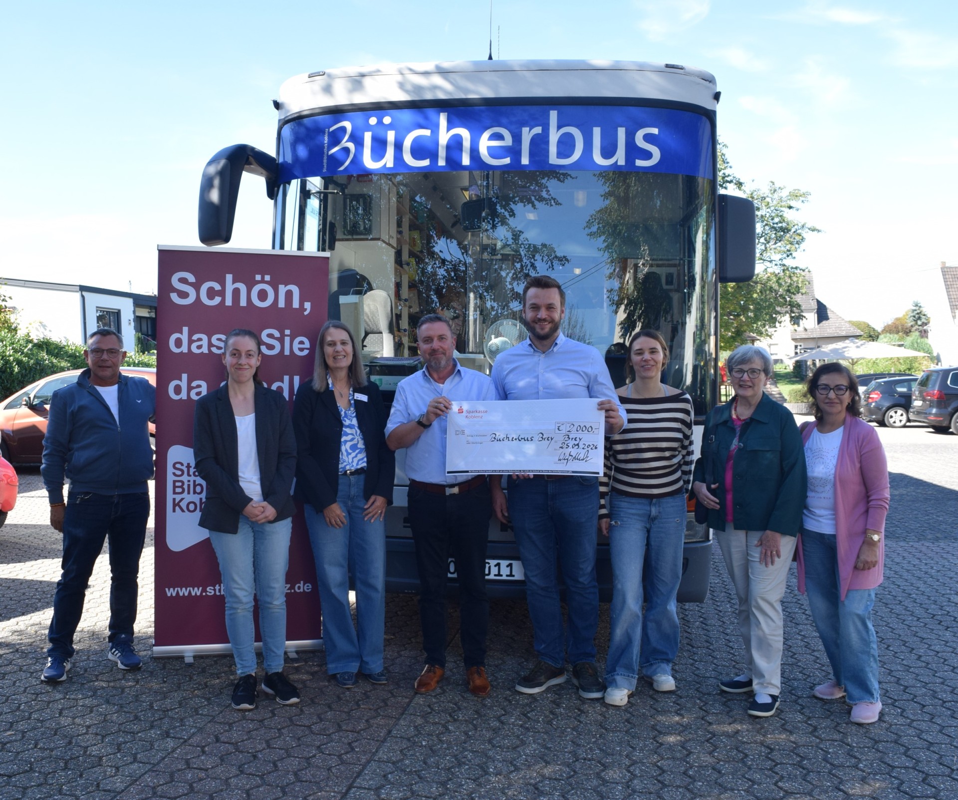 Mehrere Personen stehen vor einem Bus.