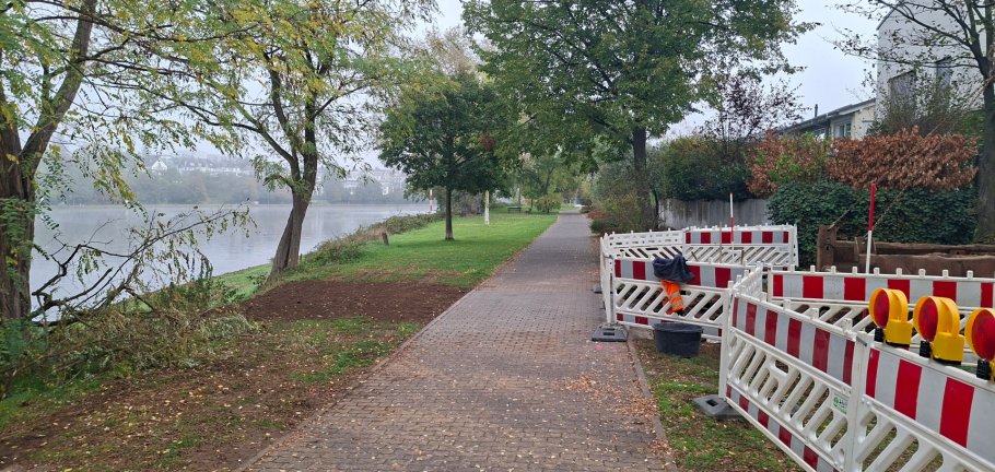 Ein Fußweg führt entlang von einem Fluss. Ein Fußweg führt entlang von einem Fluss.