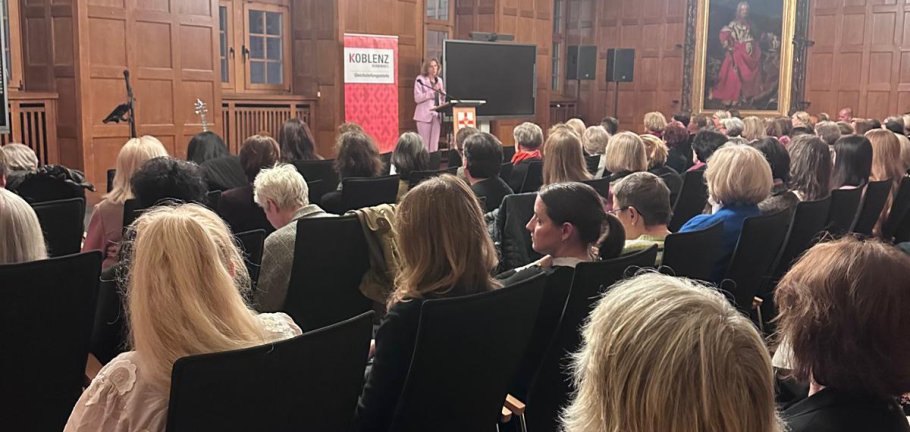 Frauen sitzen in einem Saal und hören einer Rednerin zu. Frauen sitzen in einem Saal und hören einer Rednerin zu.