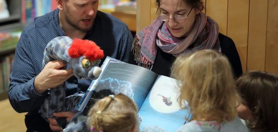 Kinder sitzen vor einem Buch und bekommen eine Geschichte erzählt. Kinder sitzen vor einem Buch und bekommen eine Geschichte erzählt.
