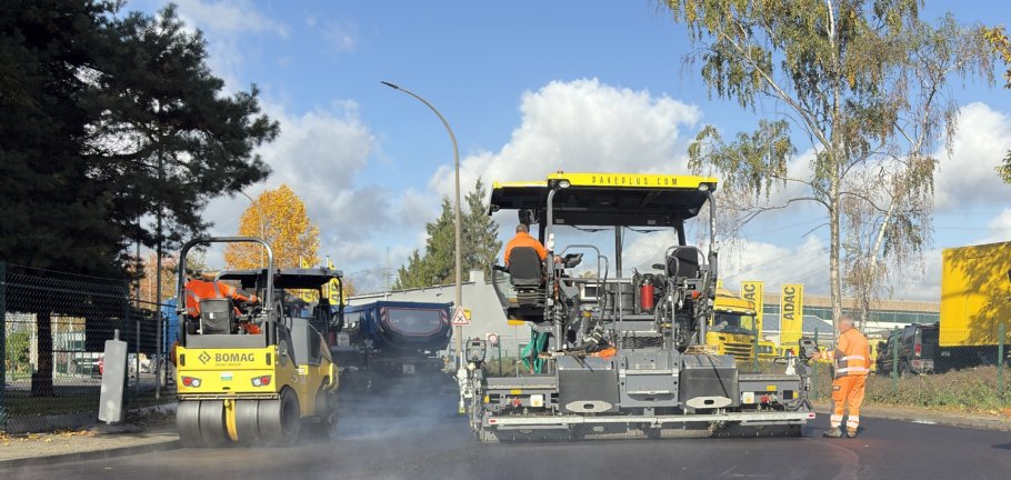 Auf einer Straße wird mit Baumaschinen Asphalt eingebracht. Auf einer Straße wird mit Baumaschinen Asphalt eingebracht.