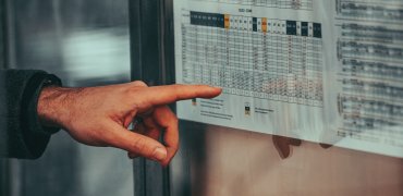 Busfahrplan Hand die auf Busfahrplan zeigt