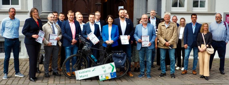 Wirtschafts- und Verkehrsministerin Daniela Schmitt und Oberbürgermeister David Langner (Bildmitte) mit Vertreter*innen der am Projekt beteiligten Kommunen, des LBM sowie weiteren geladenen Gästen. Wirtschafts- und Verkehrsministerin Daniela Schmitt und Oberbürgermeister David Langner (Bildmitte) mit Vertreter*innen der am Projekt beteiligten Kommunen, des LBM sowie weiteren geladenen Gästen.