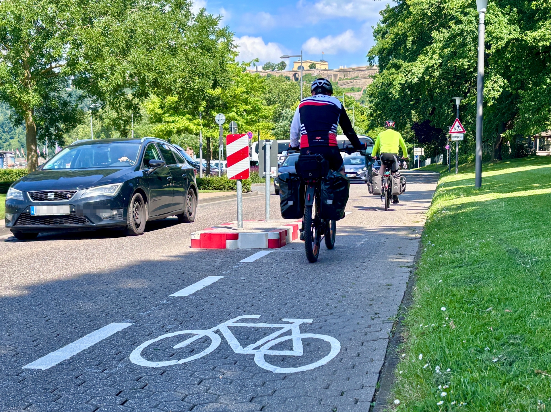 Die bestehenden Einengungen wurden angepasst und mit jeweils 1,50 Meter breiten Durchlässen für den Radverkehr ausgestattet. Ergänzend wurden Fahrradpiktogramme sowie entsprechende Leitmarkierungen aufgebracht.
