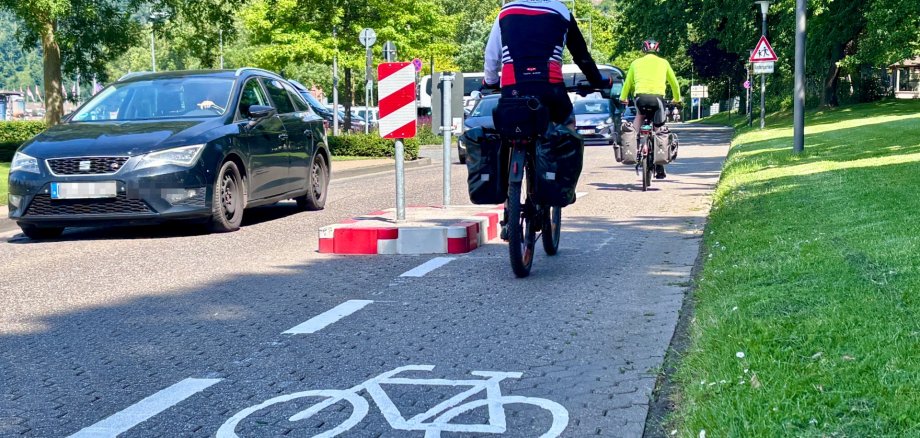 Die bestehenden Einengungen wurden angepasst und mit jeweils 1,50 Meter breiten Durchlässen für den Radverkehr ausgestattet. Ergänzend wurden Fahrradpiktogramme sowie entsprechende Leitmarkierungen aufgebracht.