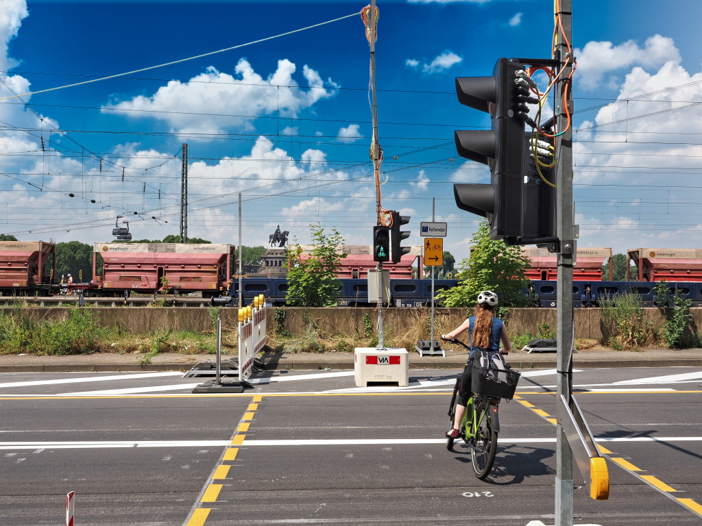 Zur sicheren Überquerung der Bundesstraße von für Radfahrenden und zu Fuß Gehenden wurde eigens eine Ampelanlage mit Anforderungstaster installiert. Auf der gegenüberliegenden Straßenseite ist der baulich getrennte Radweg für Zweirichtungsradverkehr und der Bestandsgehweg zu erkennen.
