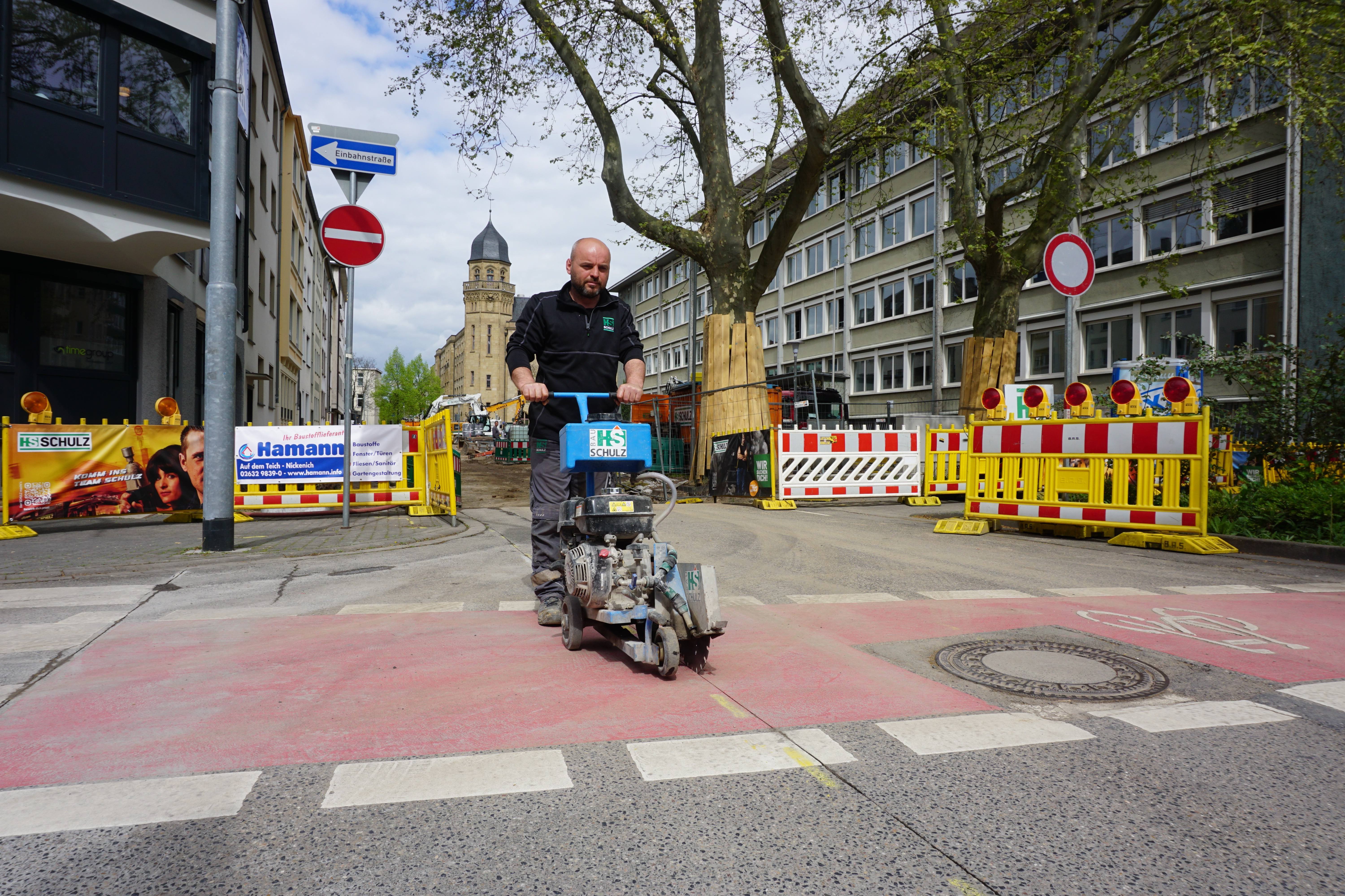 Afrim Paplekaj, Mitarbeiter der ausführenden Baufirma HS Schulz, bereitet mit dem Fugenschneider die Anschlussarbeiten in der Rizzastraße vor.