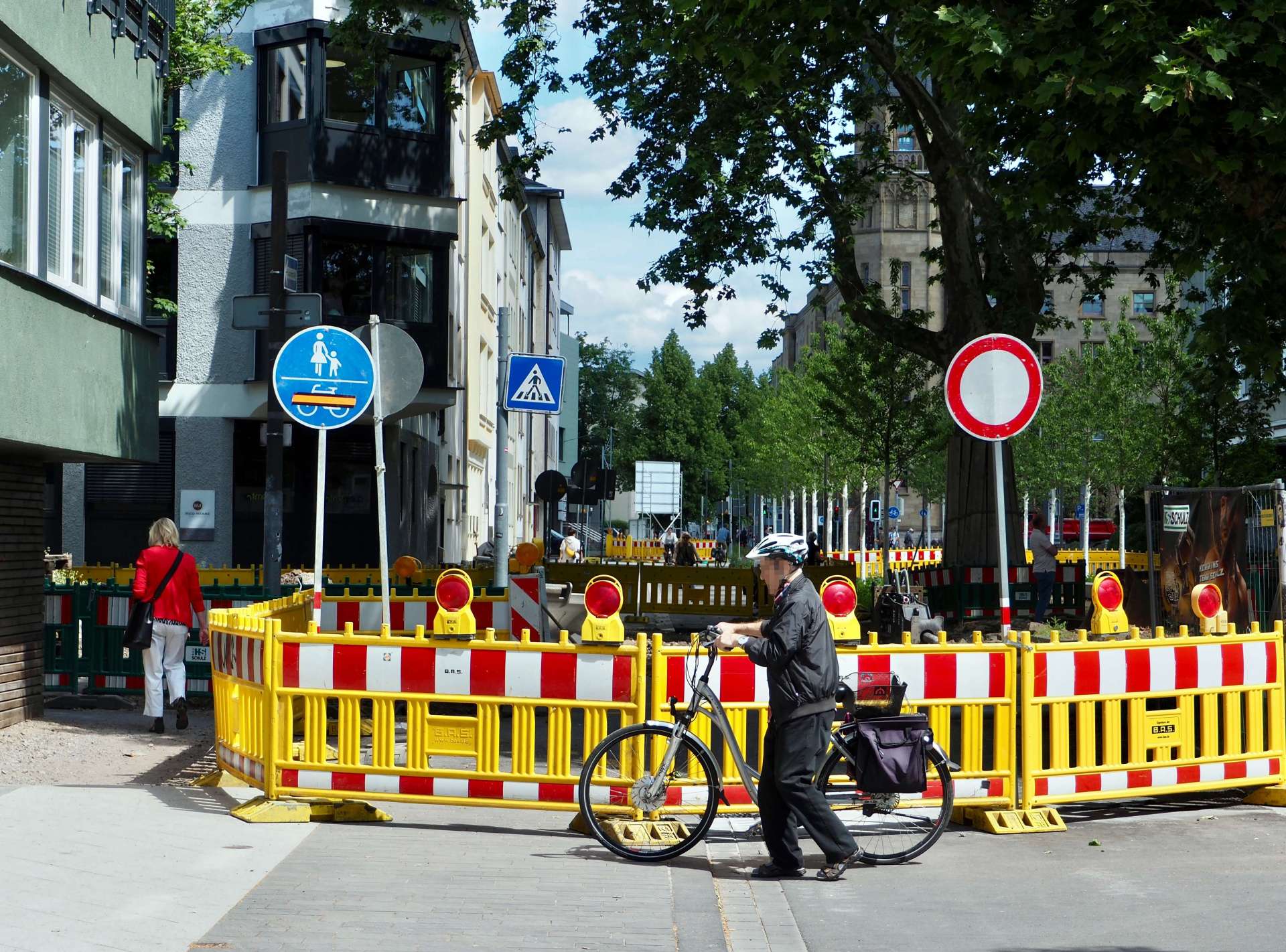 An der Kreuzung Südallee/Rizzastraße wird voraussichtlich bis August 2025 gearbeitet. An drei Stellen ist ein Durchlass für Fußgänger vorhanden. Aufgrund der baubedingt notwendigen beengten Verhältnisse müssen Radfahrende absteigen und ihre Räder schieben. An der Kreuzung Südallee/Rizzastraße wird voraussichtlich bis August 2025 gearbeitet. An drei Stellen ist ein Durchlass für Fußgänger vorhanden. Aufgrund der baubedingt notwendigen beengten Verhältnisse müssen Radfahrende absteigen und ihre Räder schieben.