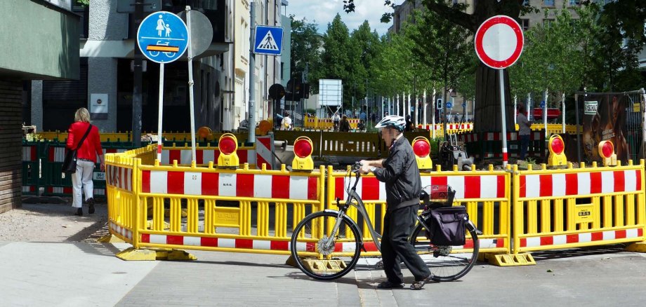 An der Kreuzung Südallee/Rizzastraße wird voraussichtlich bis August 2025 gearbeitet. An drei Stellen ist ein Durchlass für Fußgänger vorhanden. Aufgrund der baubedingt notwendigen beengten Verhältnisse müssen Radfahrende absteigen und ihre Räder schieben. An der Kreuzung Südallee/Rizzastraße wird voraussichtlich bis August 2025 gearbeitet. An drei Stellen ist ein Durchlass für Fußgänger vorhanden. Aufgrund der baubedingt notwendigen beengten Verhältnisse müssen Radfahrende absteigen und ihre Räder schieben.