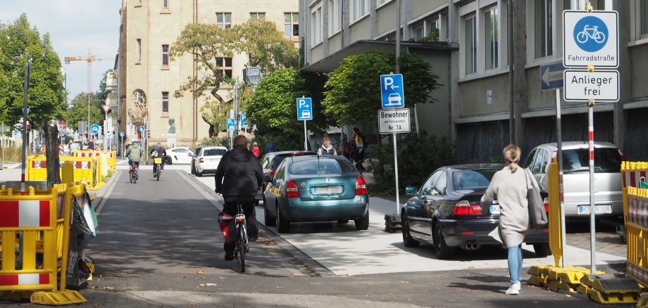Südallee im für den Verkehr freigegebenen Abschnitt vor dem Max-von-Laue-Gymnasium zwischen Rizzastraße und Friedrich-Ebert-Ring Südallee im für den Verkehr freigegebenen Abschnitt vor dem Max-von-Laue-Gymnasium zwischen Rizzastraße und Friedrich-Ebert-Ring